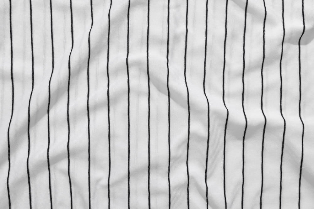 Photograph of a piece of fabric with white and black baseball pinstripes.