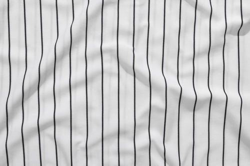 Photograph of a piece of fabric with white and black baseball pinstripes.
